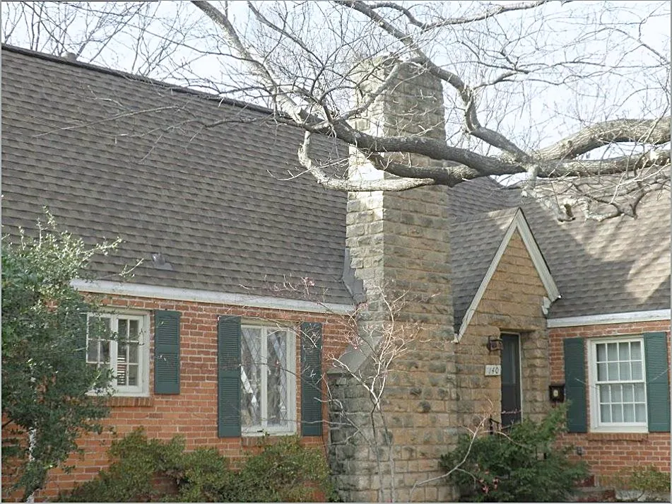 Brick chimney and shingle roof with flashing at the joint