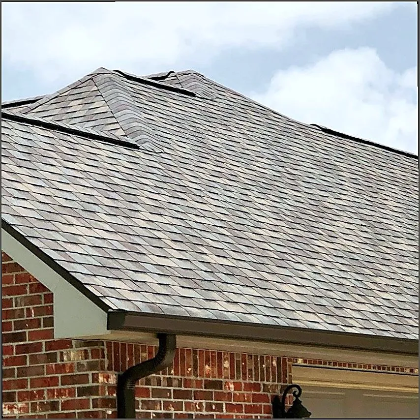 Shingle courses meeting the gutter line at a roof edge