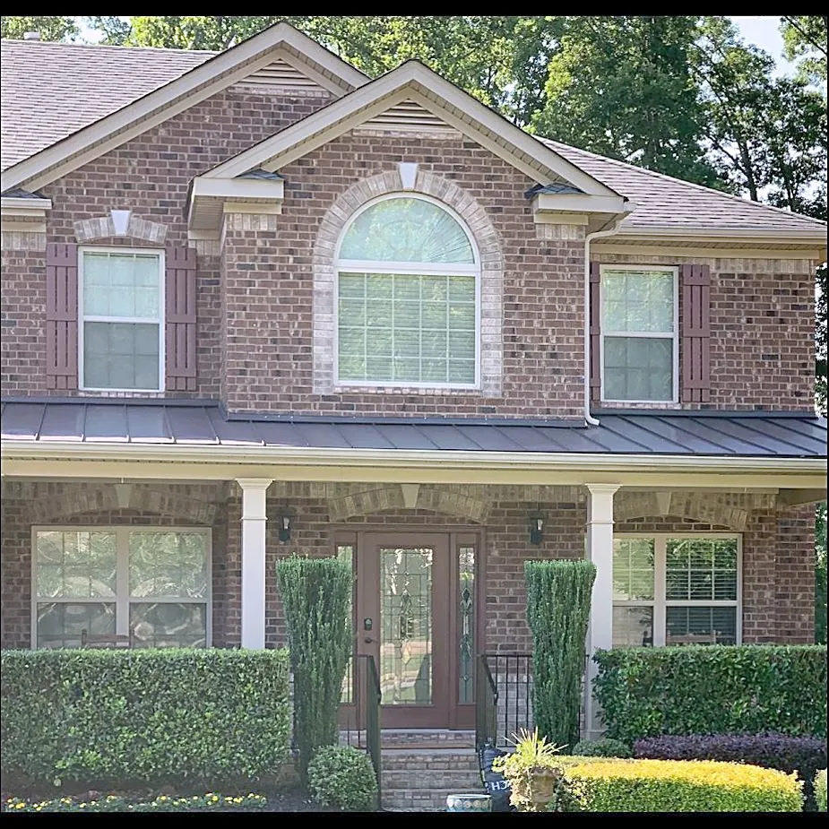 Standing seam metal porch roof under a two-story brick elevation